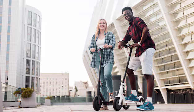 multiracial-couple-riding-electric-scooters-city-afro-american-guy-european-girl_164411-2607